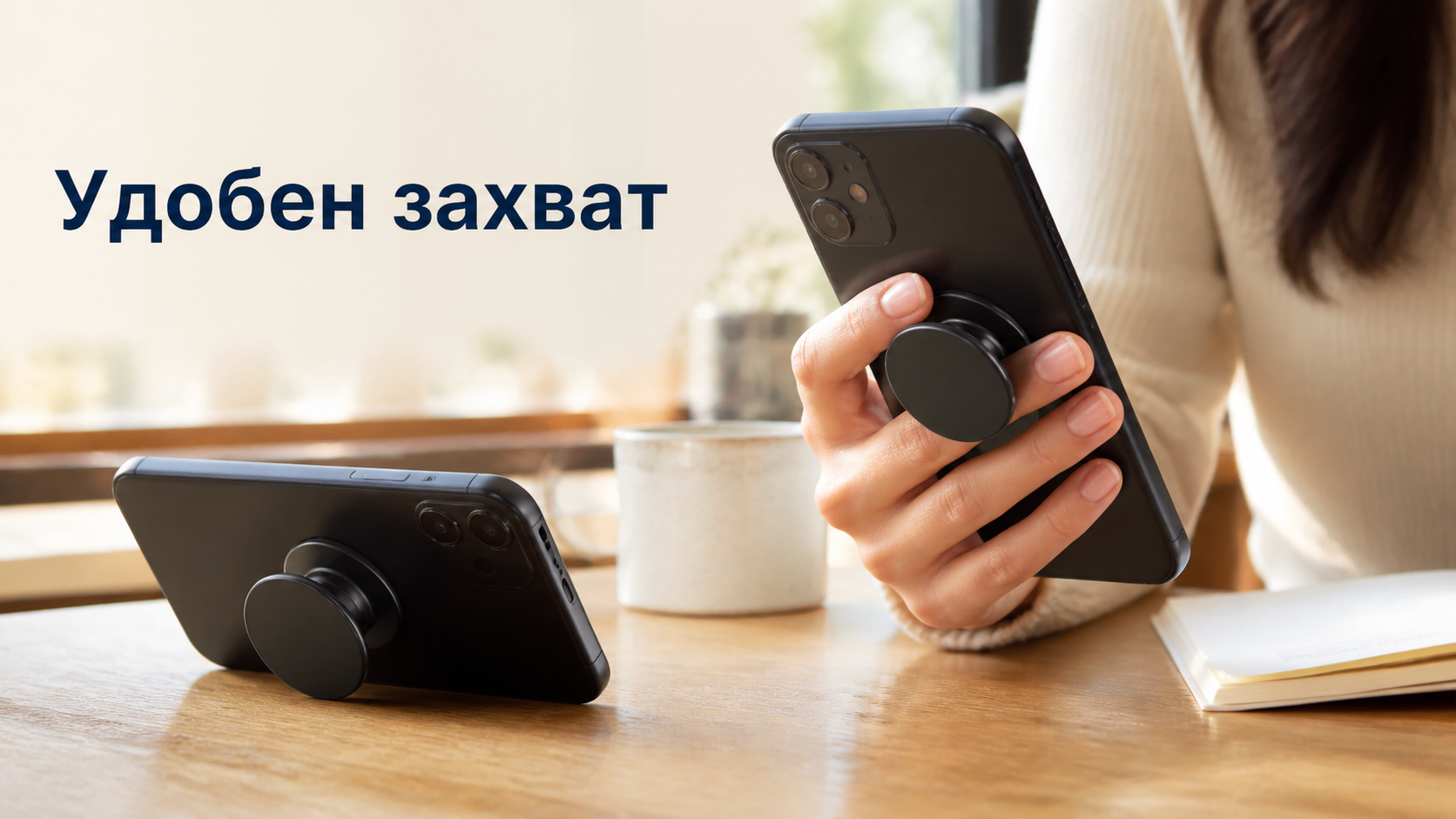 Телефон с кръгла сгъваема хватка се държи в ръка и стои подпрян на маса